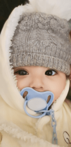 Shuhd as a baby sucking a dummy with a white glow