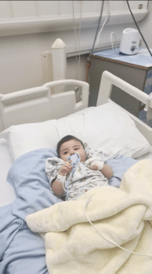 Shuhd in a hospital bed as a baby