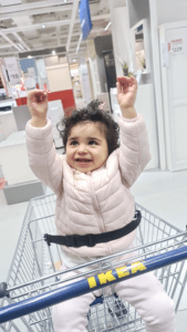 Shudh as a toddler sat in a trolley cheering