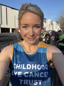 Carys is smiling in a CHECT vest running top