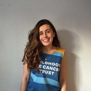 India is stood inside smiling wearing a CHECT top